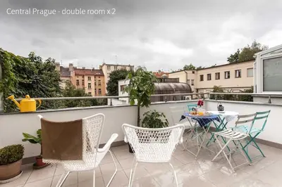 a patio with a table and chairs on a balcony at Kent Ridge Loft in Prague