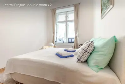 a bedroom with a bed with pillows and a window at Kent Ridge Loft in Prague