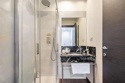a bathroom with a sink and a shower at Place of Grace - 50 Meters from Dancing House in Prague