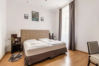 a bedroom with a bed and a chair and a window at Place of Grace - 50 Meters from Dancing House in Prague