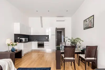 a kitchen and living room with a table and chairs at Place of Grace - 50 Meters from Dancing House in Prague