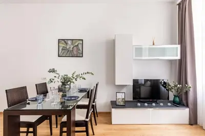 a dining room with a table and a television at Place of Grace - 50 Meters from Dancing House in Prague