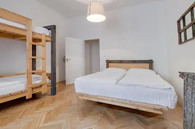 a bedroom with two bunk beds and a wooden floor at Curiosity apartments in Prague