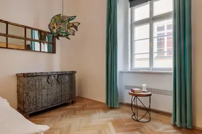a bedroom with a bed and a window and a table at Curiosity apartments in Prague