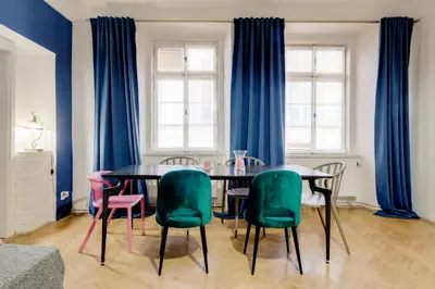a dining room with blue curtains and a table and chairs at Curiosity apartments in Prague
