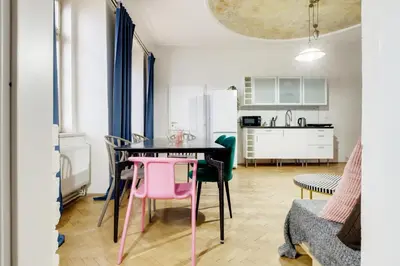 a kitchen and dining room with a pink table and chairs at Curiosity apartments in Prague