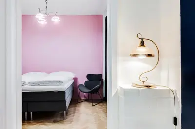 a bedroom with a bed and a pink wall at Curiosity apartments in Prague