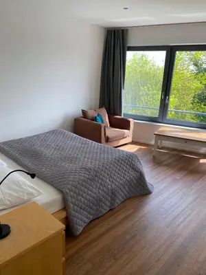 a bedroom with a bed and a couch and windows at Klapka 08 in Prague