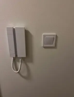 a phone hanging on a wall with a cord at Nekazanka studio apartment in Prague