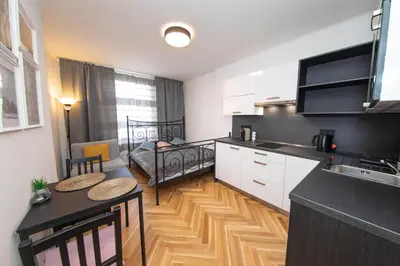 a kitchen with a table and a bed in a room at Nekazanka studio apartment in Prague