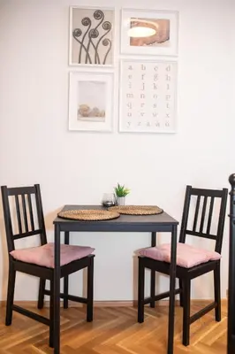 a dining room table with two chairs with pink cushions at Nekazanka studio apartment in Prague