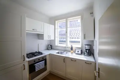 a kitchen with white cabinets and a sink and a window at Apartments Old Town Square 27 in Prague
