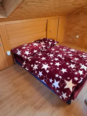 a bed with a red blanket with white stars on it at Villa Barrandovská in Prague