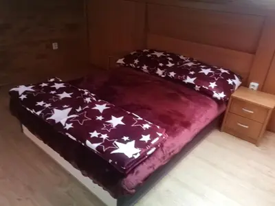 a bed with a purple blanket with white stars on it at Villa Barrandovská in Prague