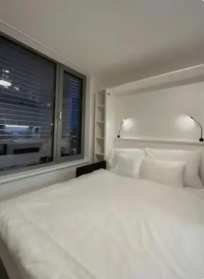a bedroom with a large white bed and a window at Mozart Apartments Prague in Prague