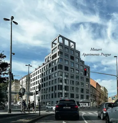 a tall white building on a city street with cars at Mozart Apartments Prague in Prague