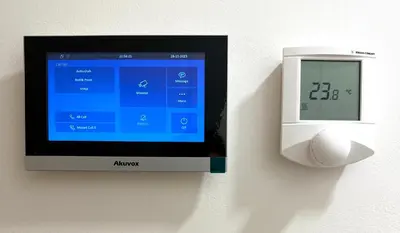 a monitor and a clock on a wall at Mozart Apartments Prague in Prague