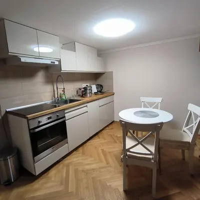a kitchen with a table and a small table with a stool at LUBERT APARTMÁNY s.r.o in Prague