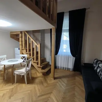 a living room with a table and a staircase at LUBERT APARTMÁNY s.r.o in Prague