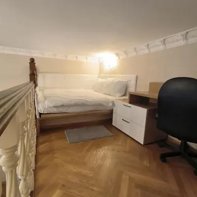 a bedroom with a bed and a desk and a chair at LUBERT APARTMÁNY s.r.o in Prague