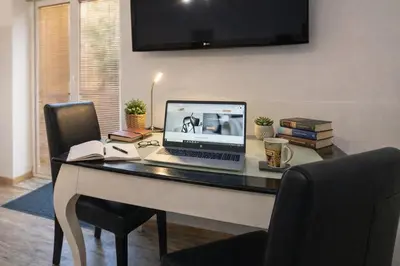 a desk with a laptop computer on top of it at Garden Suite - KindStay Suites Prague Airport in Kněžívka
