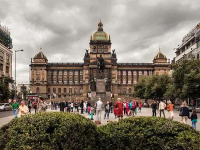 a large building with people walking in front of it at TDC33-boo in Prague