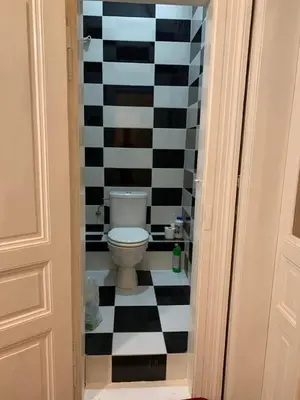 a bathroom with a toilet and a checkered floor at TDC33-boo in Prague