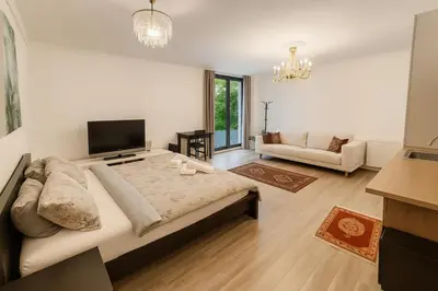 a bedroom with a large bed and a living room at Spacious Suite - KindStay Suites Prague Airport in Kněžívka