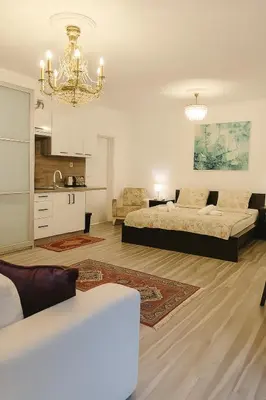 a large living room with two beds and a chandelier at Spacious Suite - KindStay Suites Prague Airport in Kněžívka
