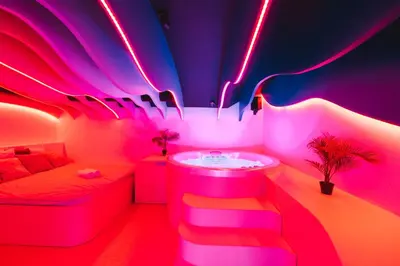 a room with a tub and a bed with neon lights at SPA SPA Legerova in Prague
