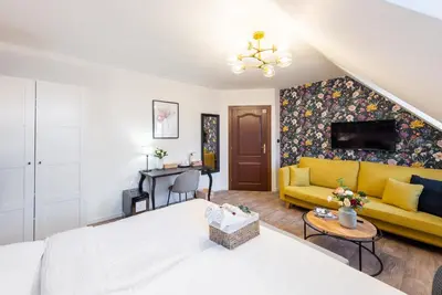a bedroom with a bed and a yellow couch at Penzion Dubina in Litoměřice