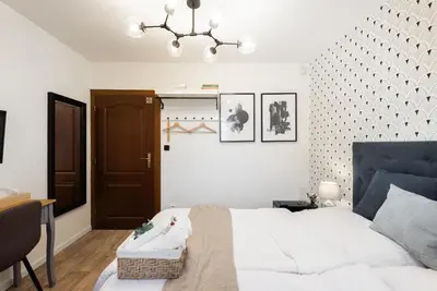 a bedroom with a white bed and a chandelier at Penzion Dubina in Litoměřice