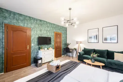a living room with a green couch and a tv at Penzion Dubina in Litoměřice