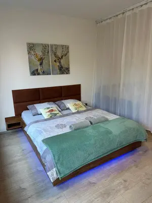 a bedroom with a bed with a green blanket on it at O2 Arena - Alex Apartment Praha in Prague