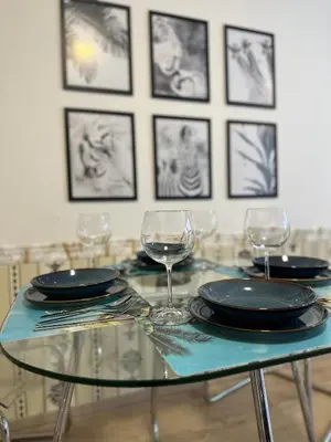 a glass table with plates and wine glasses on it at O2 Arena - Alex Apartment Praha in Prague