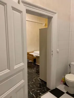 a bathroom with a toilet and a door leading to a bedroom at TDC31, boo in Prague