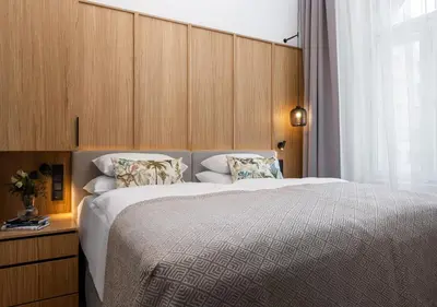 a bedroom with a large bed with a wooden headboard at R16 Residences Prague in Prague