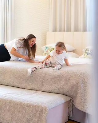 a woman and a little girl sitting on a bed at R16 Residences Prague in Prague