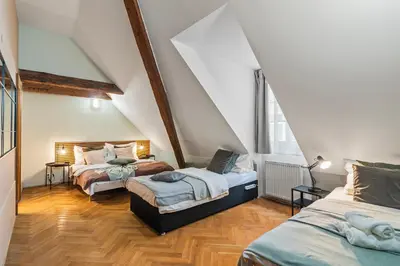 a attic room with two beds and two windows at Charles Bridge Historical APTs by Michal&Friends in Prague