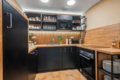 a kitchen with black cabinets and a sink at Charles Bridge Historical APTs by Michal&Friends in Prague
