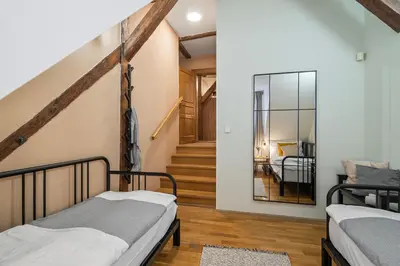 two beds in a room with a staircase at Charles Bridge Historical APTs by Michal&Friends in Prague