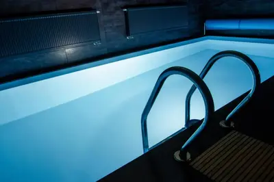 a pool with a bench and blue lighting at Pod Vojtěchem - soukromý wellness apartmán in Wotitz