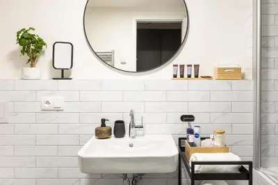 a white bathroom with a sink and a mirror at Chill in Oriental Splendour in Prague