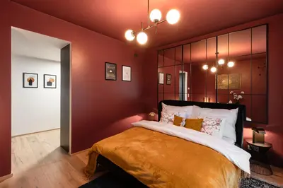 a bedroom with a large bed with red walls at Chill in Oriental Splendour in Prague