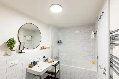 a white bathroom with a sink and a mirror at Chill in Oriental Splendour in Prague
