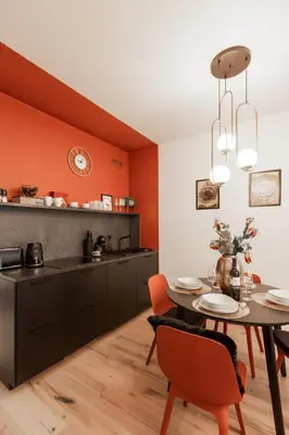 a kitchen with orange walls and a table and chairs at Chill in Oriental Splendour in Prague