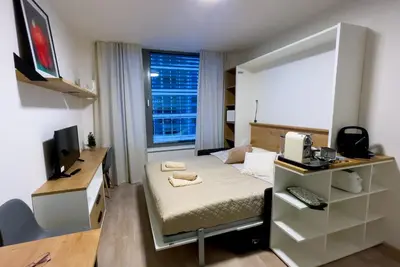 a small room with a bed and a desk with a computer at Residence My Mozart in Prague