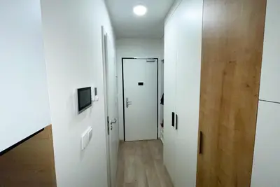 a hallway with two white doors and a television at Residence My Mozart in Prague