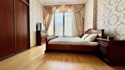 a bedroom with a bed with a dresser and a window at Stylish riverside apartment in Prague