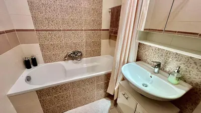 a bathroom with a bath tub and a sink at Stylish riverside apartment in Prague